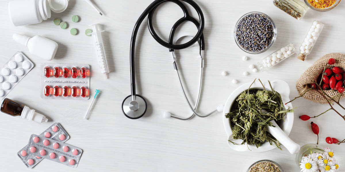 Various medications along with a stethoscope on a table.